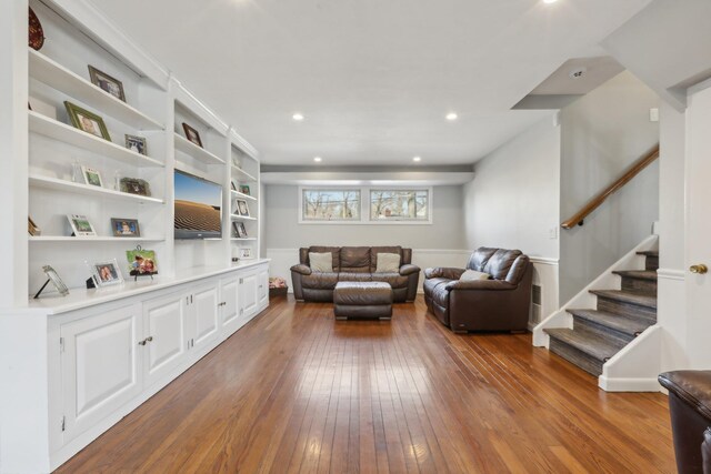 living area with stairs, recessed lighting, and hardwood / wood-style flooring