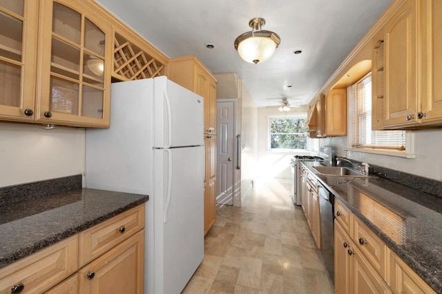 kitchen with stainless steel gas stove, a sink, freestanding refrigerator, dishwashing machine, and glass insert cabinets