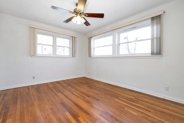 unfurnished room featuring a ceiling fan, baseboards, and hardwood / wood-style flooring