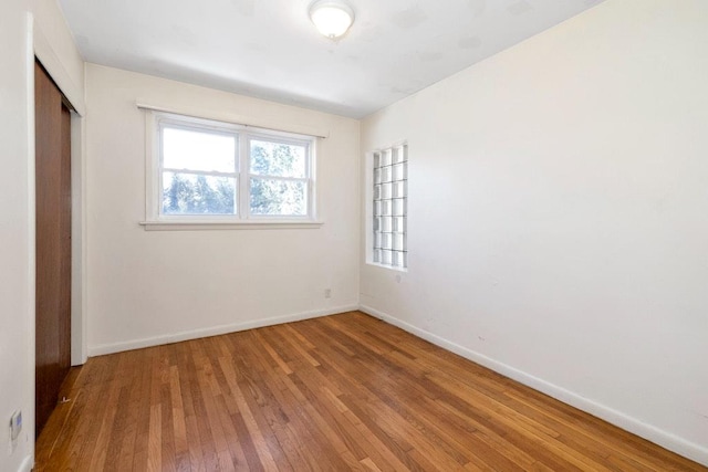 unfurnished bedroom with baseboards, a closet, and light wood finished floors