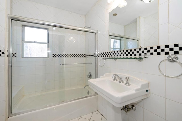 full bathroom with tile patterned flooring, tile walls, and shower / bath combination with glass door