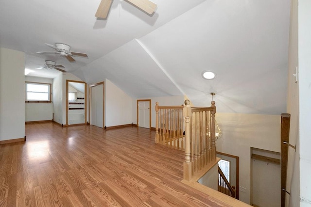 bonus room featuring light wood-style flooring, lofted ceiling, baseboards, and ceiling fan