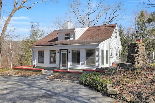 view of front of home featuring a chimney and a shingled roof