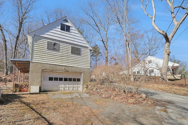 view of home's exterior with a garage, driveway, and stucco siding