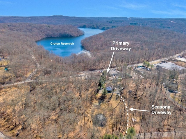 birds eye view of property with a wooded view and a water view