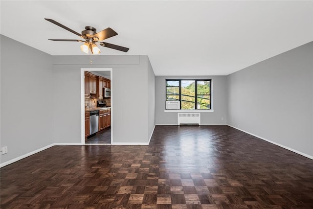 unfurnished living room with radiator, ceiling fan, and baseboards