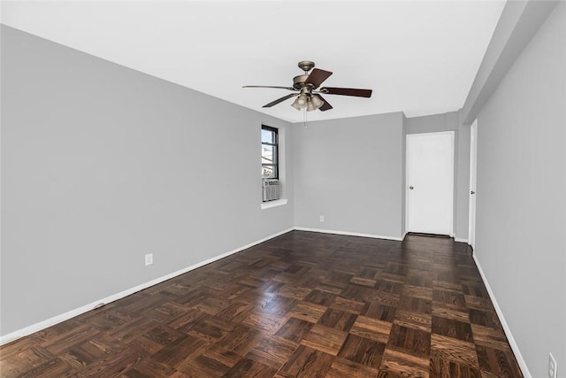 empty room featuring a ceiling fan and baseboards