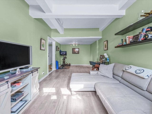 living room with beamed ceiling, light wood-style flooring, and baseboards