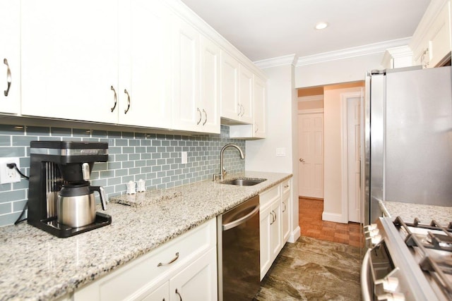 kitchen with light stone counters, crown molding, stainless steel appliances, white cabinetry, and a sink