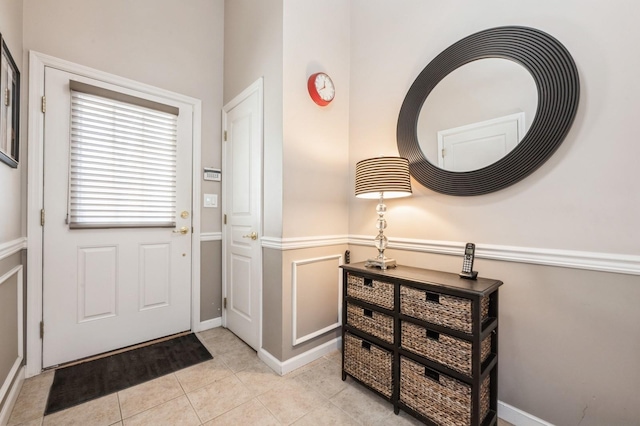 foyer entrance featuring baseboards and light tile patterned flooring