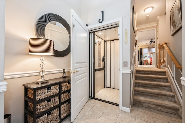 corridor featuring light tile patterned floors, stairway, elevator, and ornamental molding