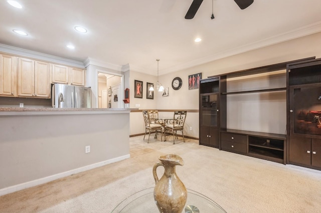 living room featuring light carpet, ornamental molding, a ceiling fan, and baseboards