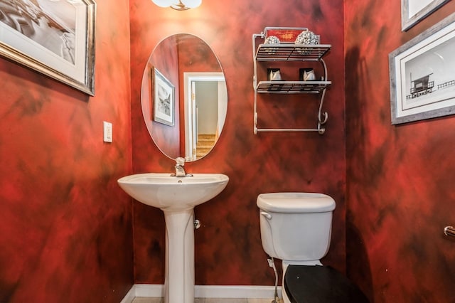 half bathroom with toilet and baseboards