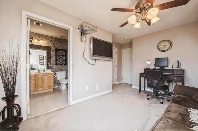 office area featuring light carpet, ceiling fan, baseboards, and a sink