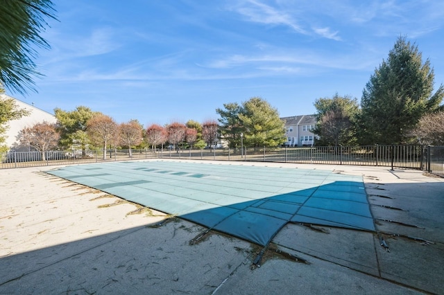 pool with a patio and fence