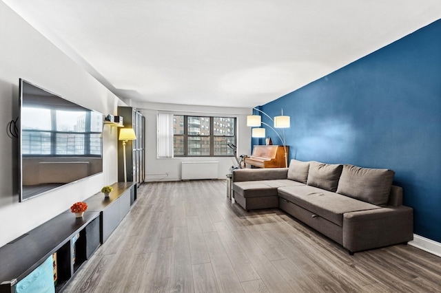 living area with baseboards and wood finished floors