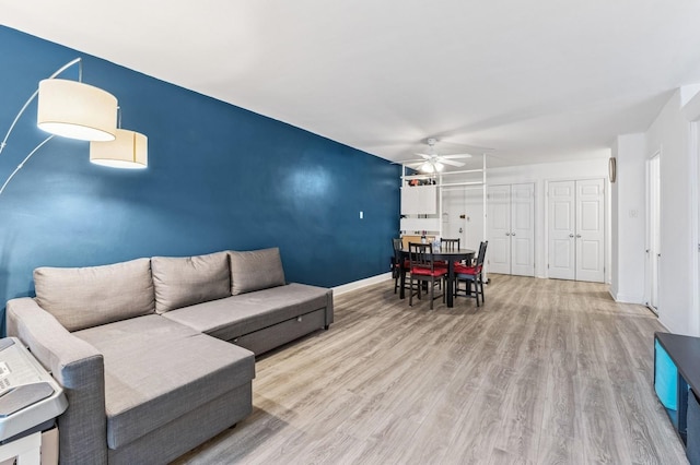 living room with ceiling fan, wood finished floors, and baseboards