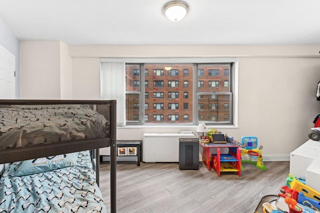 bedroom with light wood-type flooring and baseboards