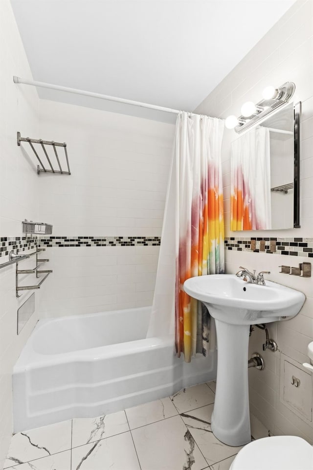 bathroom featuring toilet, tile walls, backsplash, and shower / bath combination with curtain