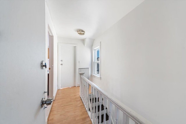 hall featuring an upstairs landing and light wood-style floors