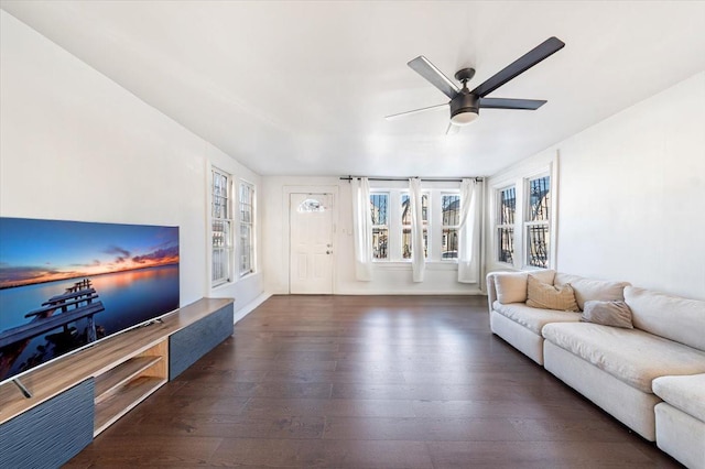 unfurnished living room featuring ceiling fan and dark wood-style flooring