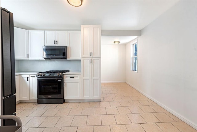 kitchen featuring white cabinetry, appliances with stainless steel finishes, light countertops, and baseboards