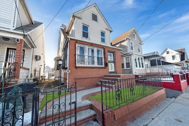 view of front facade with a fenced front yard, a residential view, and brick siding