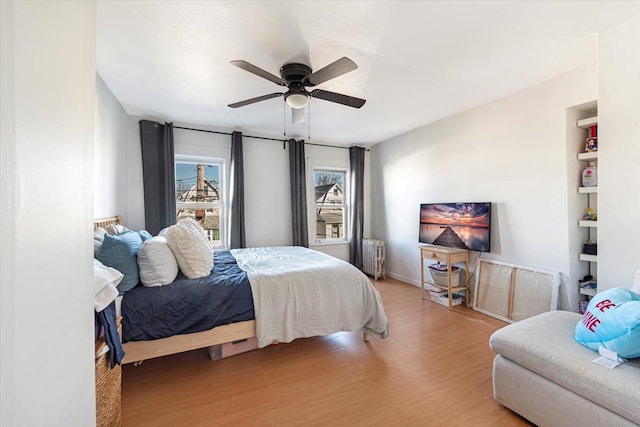 bedroom featuring radiator, a ceiling fan, and wood finished floors