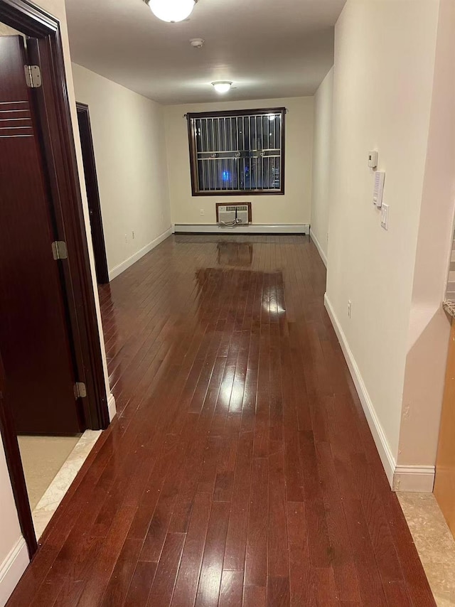 corridor with baseboards, wood finished floors, and a wall mounted air conditioner