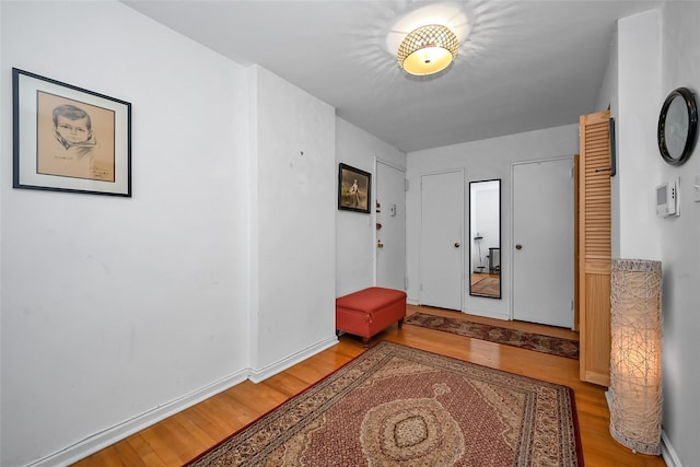 foyer with light wood-style flooring and baseboards