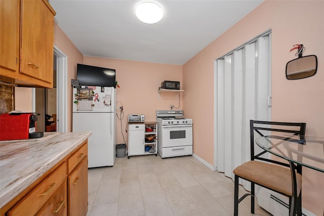 kitchen with light tile patterned floors, light countertops, white appliances, and brown cabinets