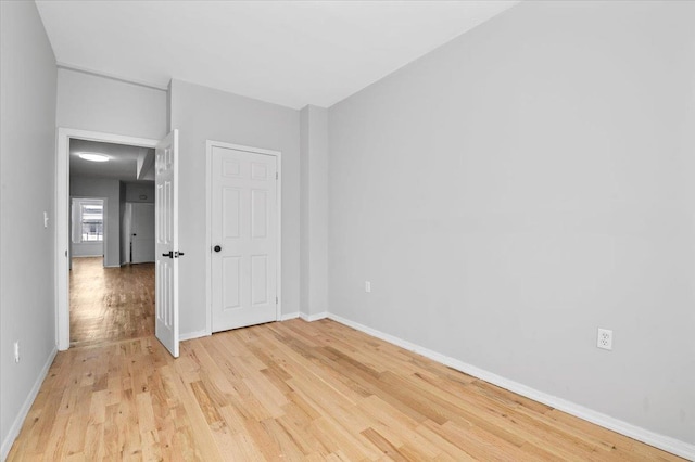 unfurnished bedroom with baseboards and light wood finished floors