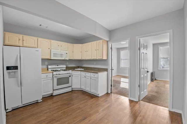 kitchen featuring white appliances, light wood-style flooring, baseboards, and radiator heating unit