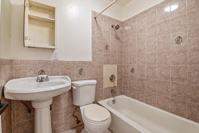 bathroom featuring a wainscoted wall, shower / bath combination, toilet, and tile walls