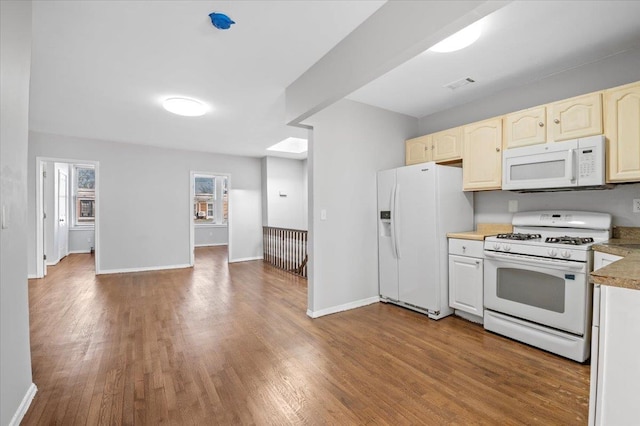 kitchen featuring light countertops, visible vents, wood finished floors, white appliances, and baseboards