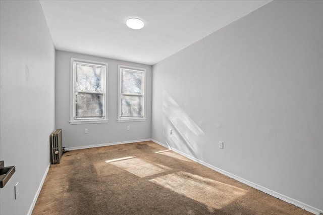 unfurnished room with radiator, baseboards, and carpet flooring