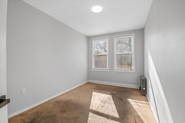 carpeted spare room featuring radiator heating unit and baseboards