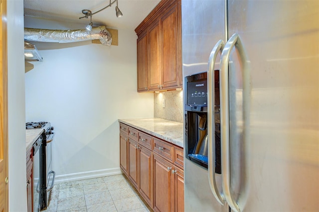 kitchen featuring brown cabinetry, stainless steel refrigerator with ice dispenser, range, and light stone countertops