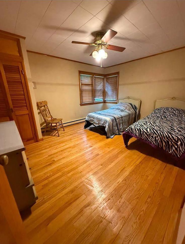 bedroom with ceiling fan, light wood-style flooring, and crown molding