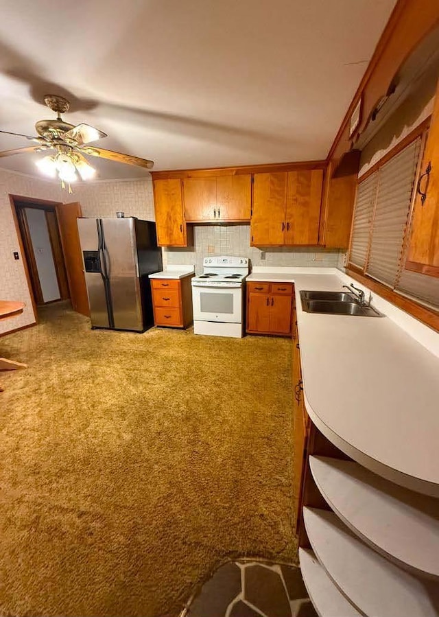 kitchen featuring brown cabinets, light countertops, white electric range, a sink, and stainless steel fridge