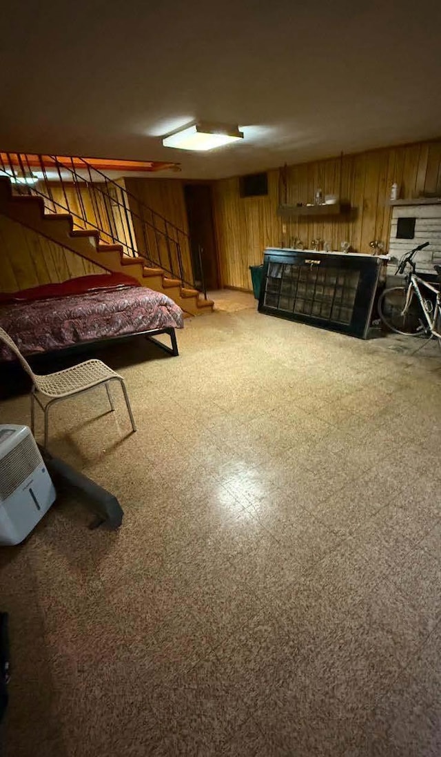 bedroom with tile patterned floors and wooden walls