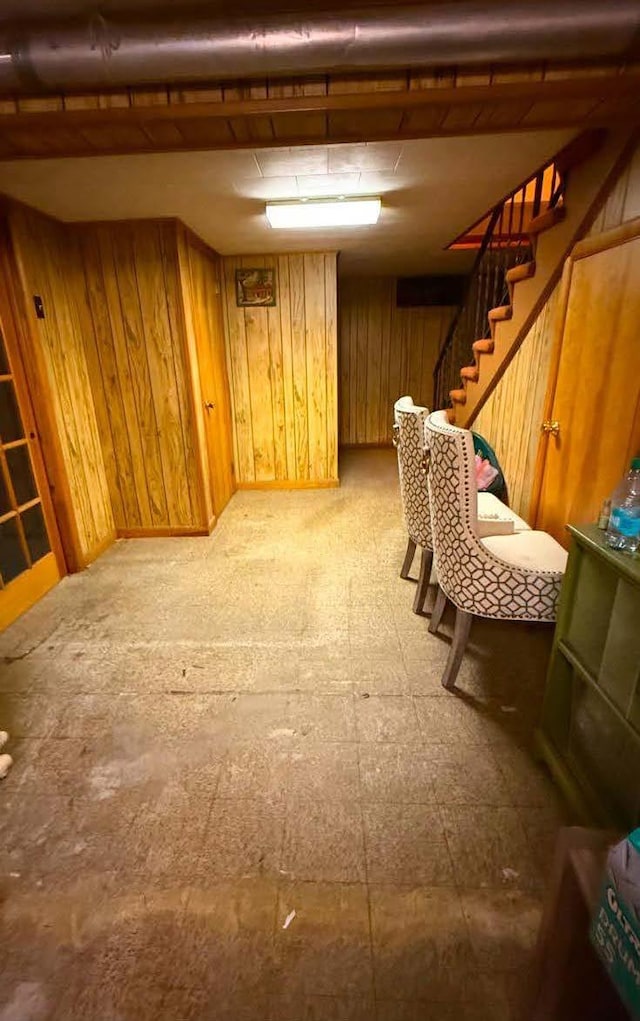 unfurnished room with wood walls, stairway, and tile patterned floors