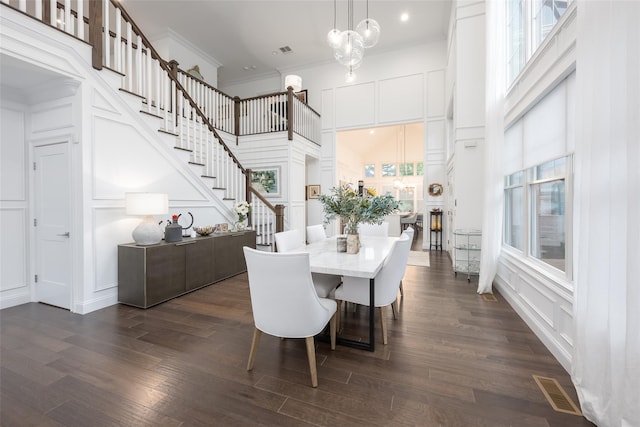 dining area with ornamental molding, plenty of natural light, visible vents, and a decorative wall