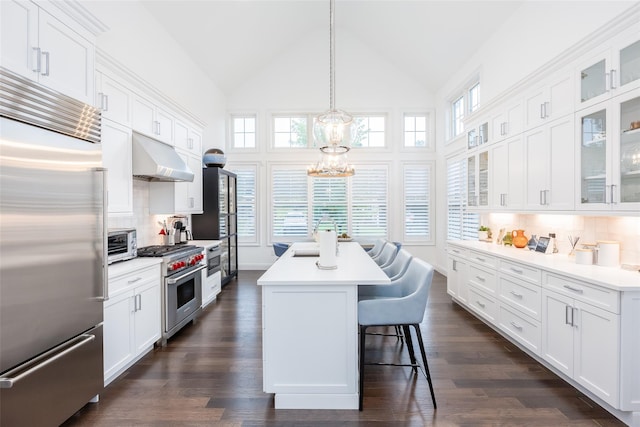 kitchen featuring light countertops, high end appliances, a kitchen island, and white cabinetry