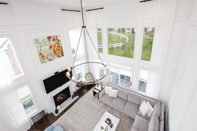 living area with a healthy amount of sunlight, a lit fireplace, and a decorative wall