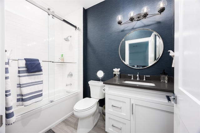 full bathroom featuring toilet, enclosed tub / shower combo, vanity, wood finished floors, and wallpapered walls