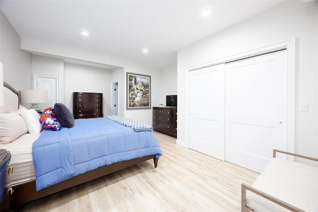 bedroom featuring light wood-style flooring, a closet, and recessed lighting