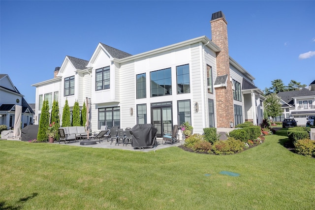 back of property with a chimney, a residential view, a yard, a patio area, and outdoor lounge area