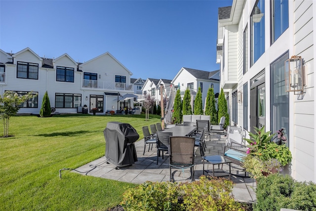 view of patio / terrace featuring outdoor dining space, a grill, and a residential view