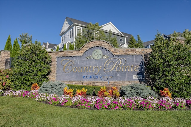 community / neighborhood sign featuring a lawn